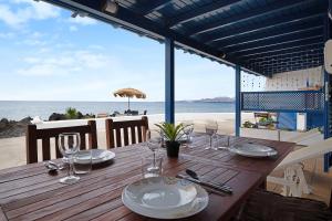 a wooden table with plates and wine glasses on the beach at Punta Marea in Punta Mujeres