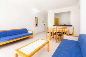 a living room with blue couches and a table and chairs at Apartament Massanet bc in Canyamel