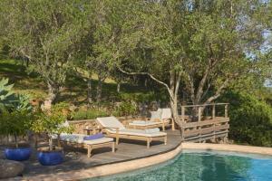 a backyard with a pool and chairs and trees at Casa Penisula in Porto-Vecchio