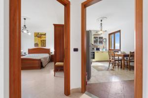 a bedroom with a bed and a kitchen with a table at La Pineta in SantʼAntìoco