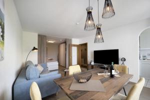a living room with a blue couch and a table at Landliebe – Seenähe & Grüntenblick in Petersthal