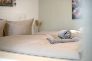 a bed with a towel and a ring on it at Landliebe – Seenähe & Grüntenblick in Petersthal