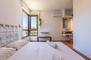 a living room with a large white bed and a window at Nuràya in Sarroch