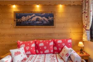 a room with a bed with red and white pillows at Amanuq lovely apartment in Chamonix