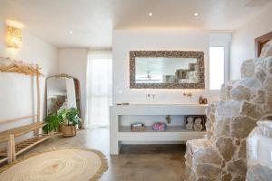 a bathroom with a stone fireplace and a mirror at Casa Marea - Villa Con Jacuzzi in Corralejo +21 photos