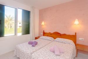 a bedroom with a bed with two purple pillows on it at Apartamento Cala en Forcat 34 in Cala en Blanes +18 photos