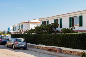two cars parked on a street in front of houses at Apartamento Cala en Forcat 34 in Cala en Blanes