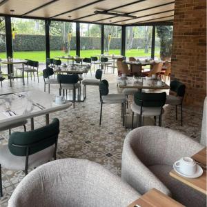 a dining room with tables and chairs and tablesearcher at Hotel Habitel Prime in Bogotá