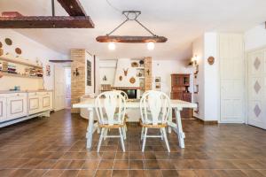 a kitchen with a white table and white chairs at Nuràya in Sarroch