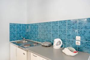 a kitchen with a sink and blue tiles on the wall at Pico Bello Patmos 14 in Patmos +26 photos