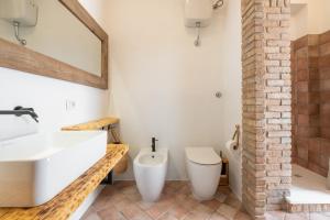 a bathroom with a white sink and a toilet at Nuràya in Sarroch