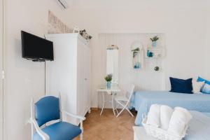 a bedroom with a bed and a tv and a table at Casa Petros in Marsala