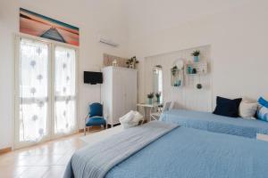 a bedroom with two beds and a desk and a tv at Casa Petros in Marsala