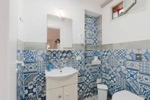 a bathroom with blue and white tiles on the wall at Casa Petros in Marsala +33 photos