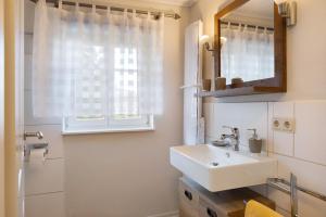 a bathroom with a sink and a mirror at Ferienwohnung im alten Vierseithof in Friedewald +19 photos