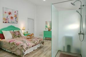 a bedroom with a bed and a glass shower door at Los Cipreses in Ingenio +22 photos