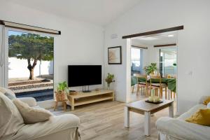 a living room with a television and a dining room at Los Cipreses in Ingenio