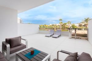 a patio with chairs and tables on a balcony at Apartment in Mil Palmeras in Pilar de la Horadada