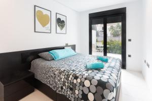 a bedroom with a bed with blue pillows on it at Apartment in Mil Palmeras in Pilar de la Horadada