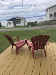 two benches sitting on top of a wooden deck at Chalet Le Pointu - St-Lawrence River View in Rivière-du-Loup