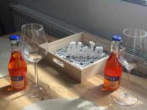 a table with two glasses and a box of wine at Ferienwohnung am Halbmond in Badbergen