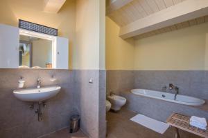 a bathroom with a sink and a tub and a toilet at Villa Limone in Trequanda +20 photos