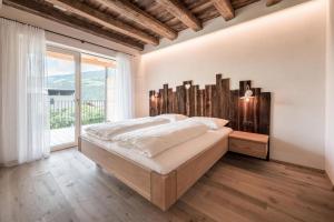 a bedroom with a large bed and a large window at Sommersbergerhof 1935 in Bressanone