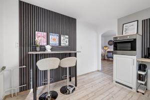 a kitchen with a counter and two stools in a room at Haus Flora Bianca in Albstadt