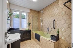 a bathroom with a green tub and a sink at Haus Flora Bianca in Albstadt