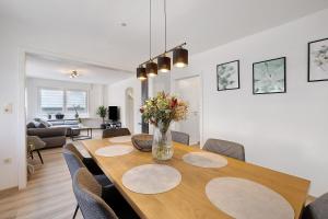 a dining room table with chairs and a vase of flowers at Haus Flora Bianca in Albstadt +28 photos