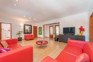 a living room with red furniture and a flat screen tv at Villa Ses Basses in Mancor del Valle