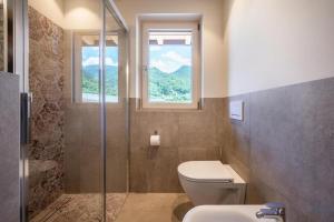 a bathroom with a toilet and a window at Sommersbergerhof 1935 in Bressanone +19 photos