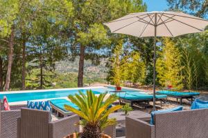 a pool with a table and an umbrella at Villa Ses Basses in Mancor del Valle