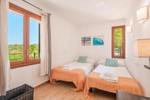a bedroom with two beds and a window at Villa Ses Basses in Mancor del Valle +17 photos