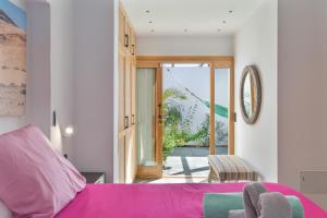 a living room with a pink couch and a sliding glass door at El Alcaidón in Tías