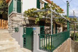 a house with a green door and stairs at Villa Rústica - Casa da Lurdes in Ribeira Brava