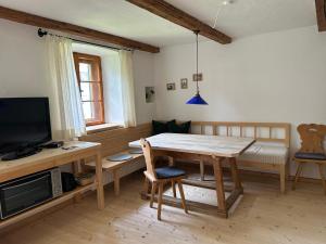 a living room with a wooden table and a television at Ferienwohnung Filser in Unterammergau