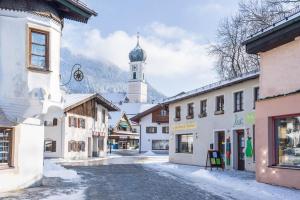 a street in a town with a clock tower at Ferienwohnung Filser in Unterammergau +10 photos