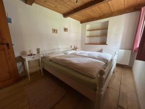 a bedroom with a white bed and a table at Ferienwohnung Filser in Unterammergau