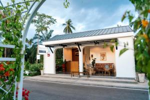 a house with a porch with a table and chairs at on and on haus in Ban Na Nian