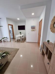 a living room with a table and a tv at Apartamento Rincón La Ballena in Rota