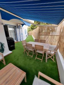 a patio with a table and chairs on grass at Apartamento Rincón La Ballena in Rota