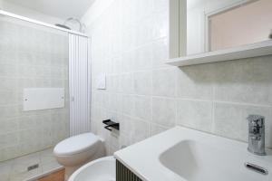a white bathroom with a toilet and a sink at Biancolino Apartments in Nardò +18 photos