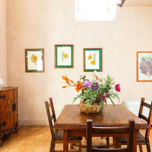a dining room table with a basket of flowers on it at Baia delle Rocce Verdi Resort in Naples