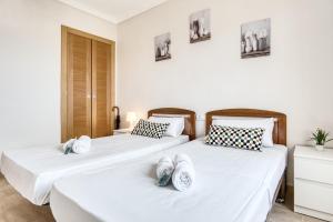two beds in a room with white walls at Sunflower Puerto Rico in Santa Pola