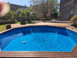 a swimming pool with a wooden deck and blue water at Maison d'hôte Mas de Castille entre Uzès et le pont du Gard in Argilliers +48 photos