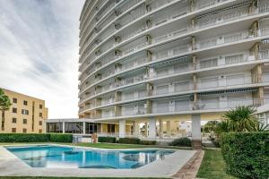 an apartment building with a pool in front of it at Marinada in L'Escala