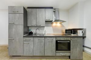 a kitchen with stainless steel cabinets and a sink at Ferienwohnung Tiefer Garten in Itzehoe