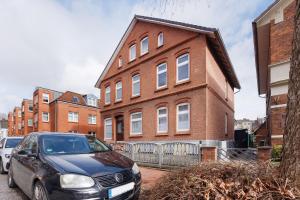 a car parked in front of a brick building at Ferienwohnung Tiefer Garten in Itzehoe