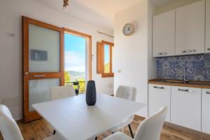 a kitchen with a white table and white chairs at Casa Jerzu S'essia de su santu in Jerzu